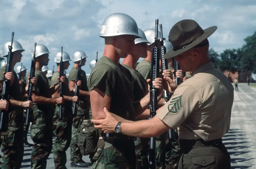 Un instructeur inspecte la tenue et la posture de jeunes engagés lors de l'instruction initiale