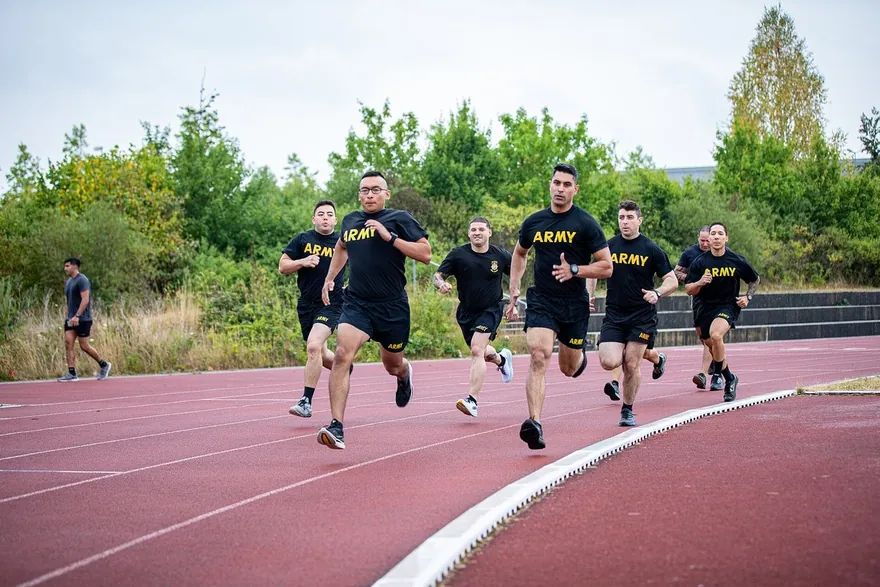 Un groupe de militaires court ensemble sur une piste d'athlétisme